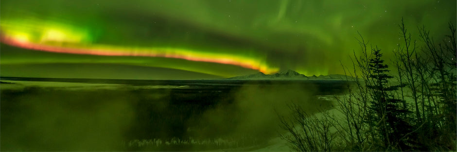Fast-moving aurora borealis streaking across panoramic Alaska night sky