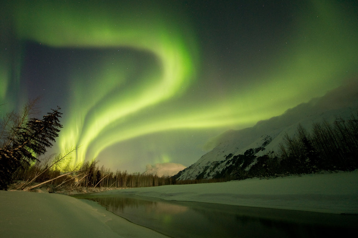 Emerald green aurora borealis winds sweeping across Alaska landscape