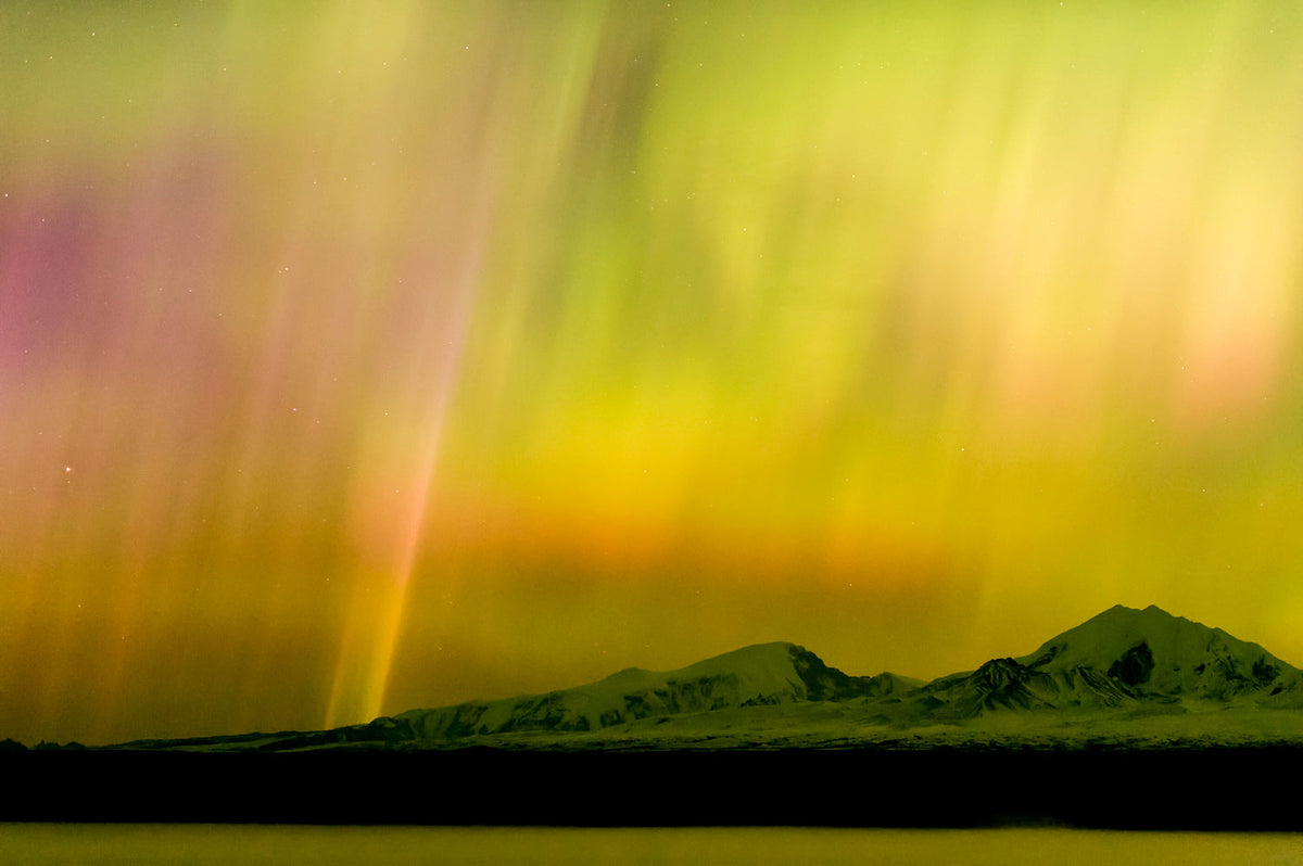 Rainbow spectrum aurora borealis arching over Alaska midnight landscape